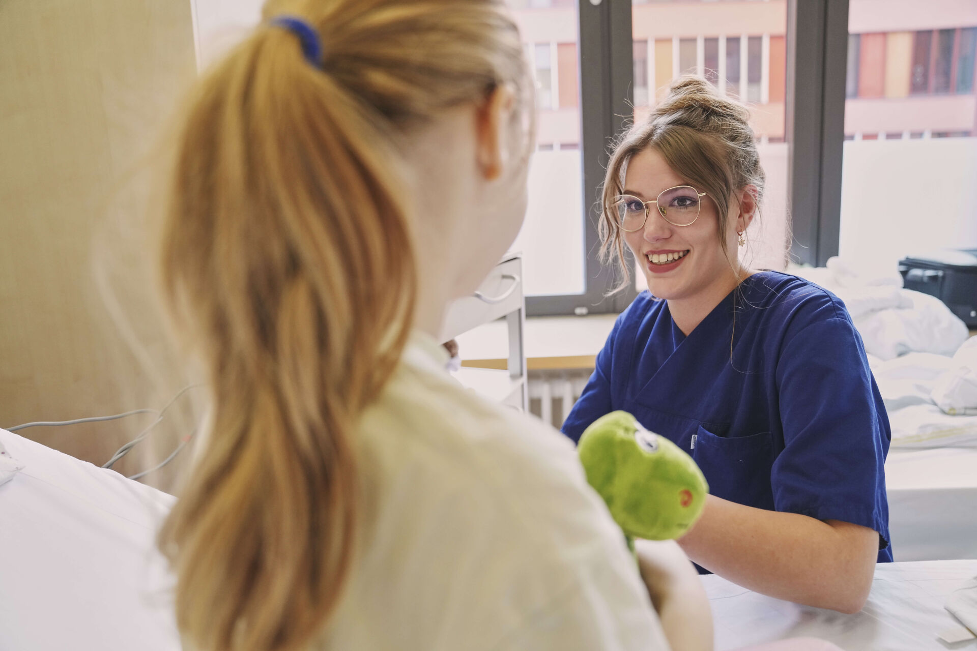 Das Bild zeigt eine Kinderkrankenpflegerin bei der Untersuchung einer Patientin.